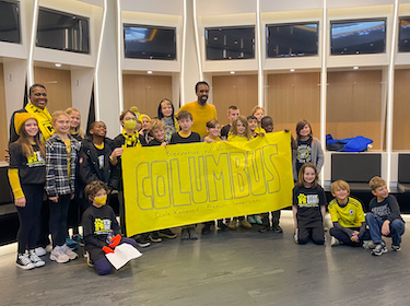 Students with Coach Nancy in the locker room